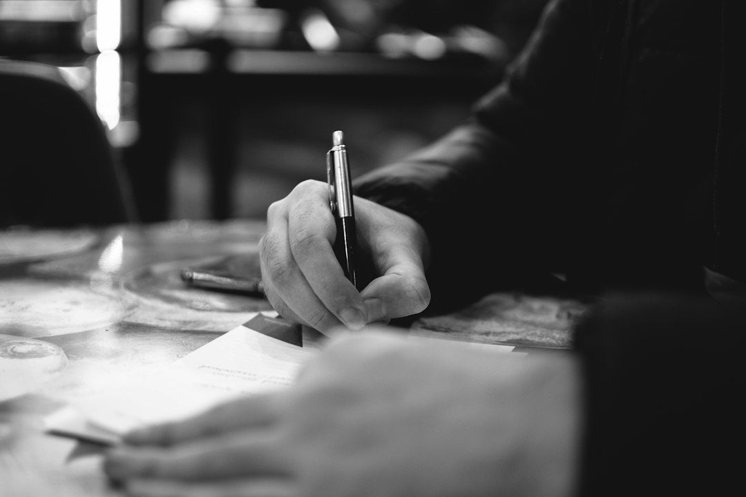 Hand schrijft met een pen aantekeningen op een vel papier